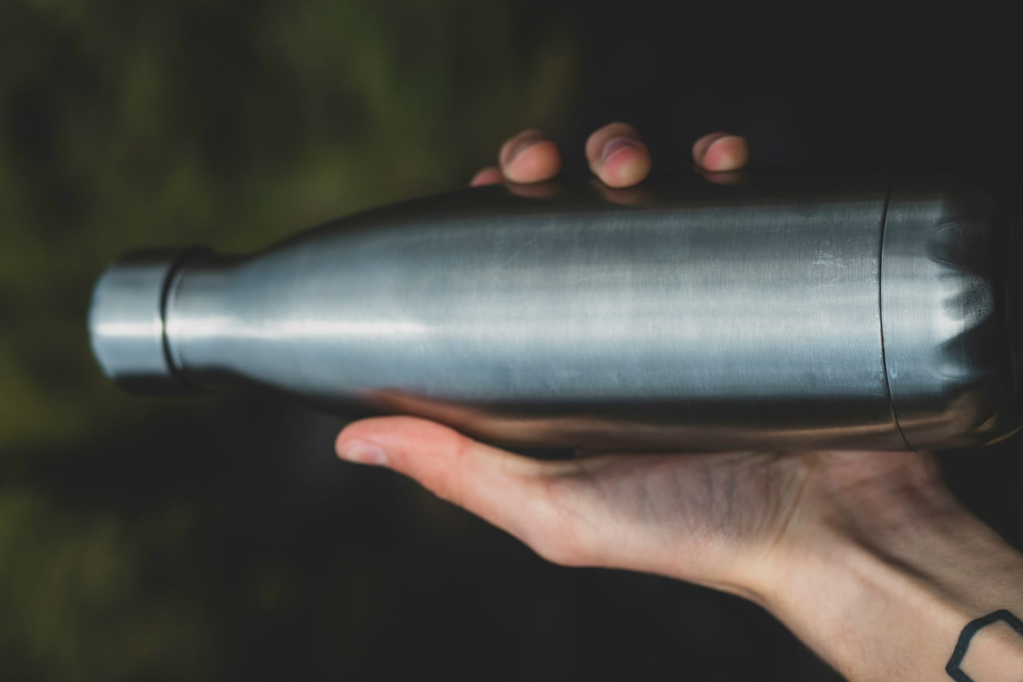 person holding gray bottle